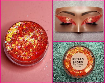 May include: A small jar of orange glitter with iridescent flakes. The jar has a white label with the text "NO TAN LINES The Pretty Tribe".