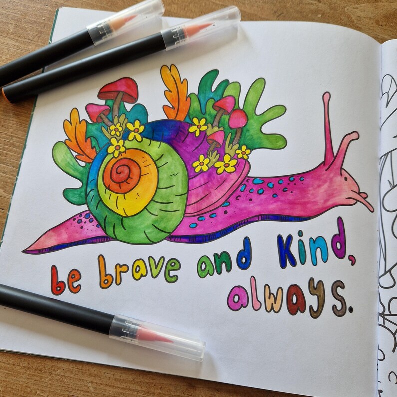 Op de afbeelding: Een kleurrijke illustratie van een slak met een regenboog-schelp en een roze lichaam. De slak is omringd door paddenstoelen en bloemen. De tekst "be brave and kind, always." staat onder de slak.