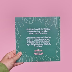 Op de afbeelding: Een groen kleurboek met een fantasierijk ontwerp met een kikker, een slak en andere boswezens. De omslag heeft de tekst "of sprites and stitches".