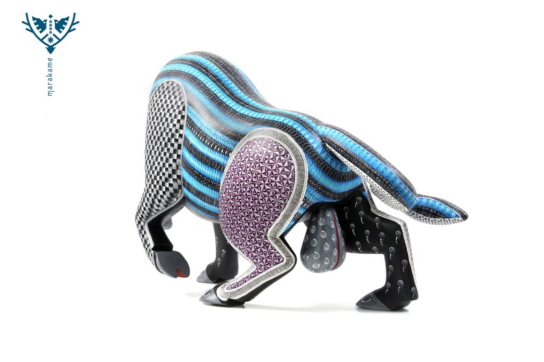 May include: A wooden bull sculpture with intricate carvings and a blue, black, and purple colour scheme. The bull is in a charging pose with its head lowered and horns pointed forward.