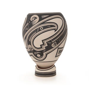 May include: A bulbous ceramic vase featuring a cream-colored base with intricate black geometric patterns and stylized avian motifs. The vessel sits on a matching circular pedestal base, showcasing detailed line work, cross-hatching, and bold curves.