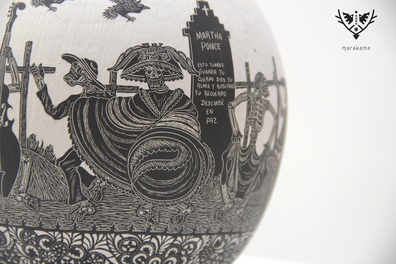 May include: Black and white ceramic skull with a black and white floral design. The skull is wearing a hat and has a skeletal face. The text on the tombstone reads "MARTHA POINCE ESTA TUMBA STUARDA TU CUERPO DIOS TU ALMA Y NUSTA TO RECUERDO DESCANSE EN PAZ".
