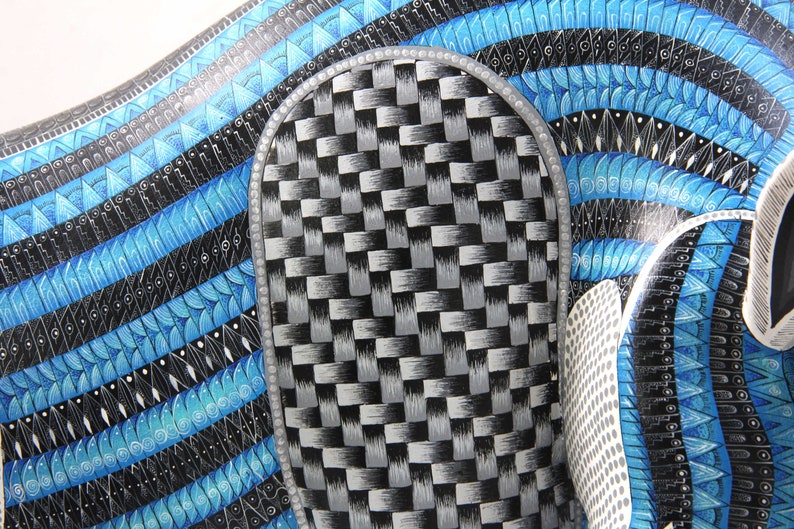 May include: A close-up of a blue and black patterned design with a silver and black checkered pattern in the centre.