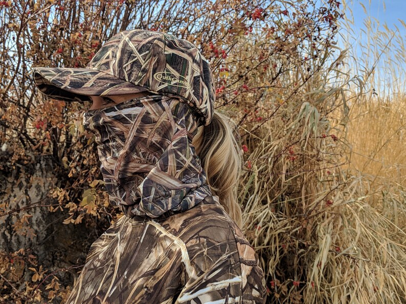 K&ouml;nnte beinhalten: Eine Person tr&auml;gt eine braune und beige Tarnjacke und eine braune und beige Tarnbaseballkappe mit dem Schriftzug "Duck Commander" auf der Vorderseite. Die Person tr&auml;gt eine braune und beige Tarnmaske.