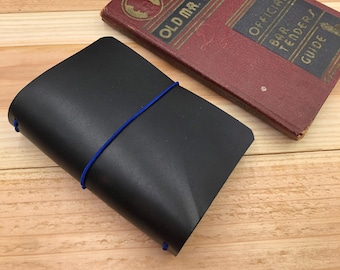 Copertina per taccuino da viaggio in pelle nera formato passaporto, personalizzabile in base alle dimensioni e al colore dell'elastico.