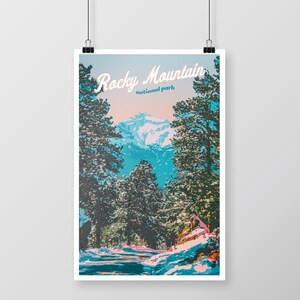 May include: A poster featuring a scenic view of the Rocky Mountains. The image showcases a snow-covered mountain range framed by tall evergreen trees. The words "Rocky Mountain national park" are written in a stylized font across the top.