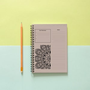 Puede incluir: Una libreta beige de espiral con un dise&ntilde;o de mandala en blanco y negro en la portada. La libreta tiene una secci&oacute;n para "To Do" y una secci&oacute;n para "Notas". Un l&aacute;piz amarillo est&aacute; acostado junto a la libreta sobre un fondo azul claro y amarillo.