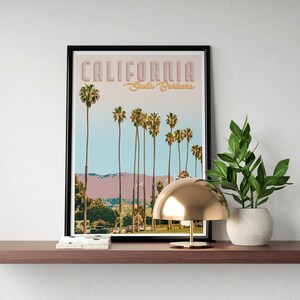 May include: A framed print with a retro design featuring palm trees and the text "CALIFORNIA Santa Barbara".