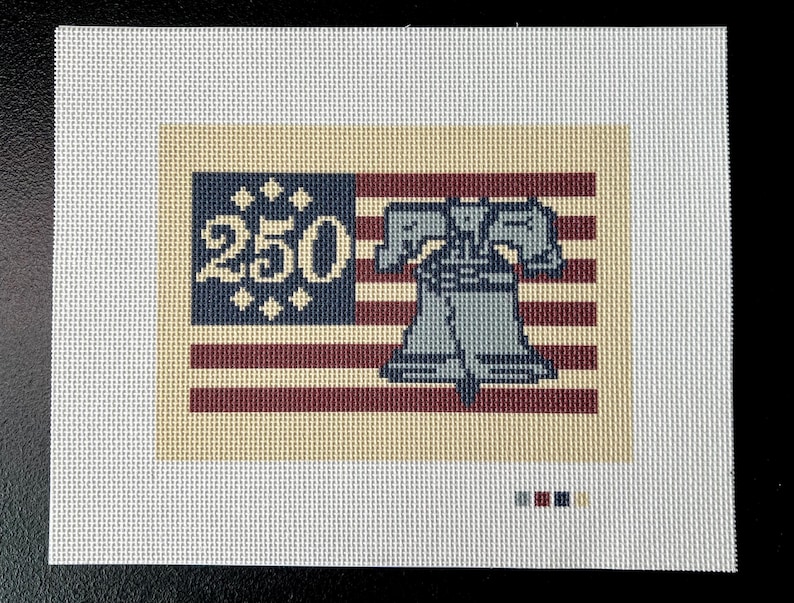 May include: Needlepoint canvas featuring a patriotic design. The artwork includes a blue section with the number "250" and stars, and a red and white striped section. A gray Liberty Bell is centered on the design.