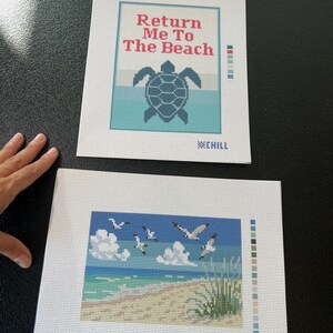 May include: Two needlepoint canvases. One features a turtle and the text "Return Me To The Beach". The other depicts a beach scene with seagulls, clouds, and ocean waves. Both have the word "CHILL" at the bottom.