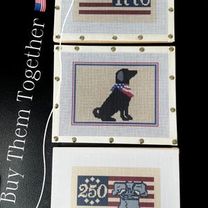 May include: Three framed needlepoint pieces with patriotic themes. The top piece features a flag design with the number "1776". The middle piece shows a black dog wearing a patriotic bandana. The bottom piece displays a flag design with the number "250" and the Liberty Bell.