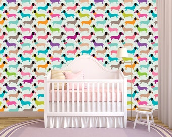 May include: A nursery with a white crib, a lamp, and a patterned wall. The wall features a repeating pattern of colorful dachshund dogs on a light green background. The dogs are in various colors, including pink, blue, and orange.