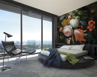 Pode incluir: Um interior de quarto com um grande mural floral na parede. O mural apresenta um buquê de flores rosa, brancas e laranja com folhas verdes. Uma cama redonda com um edredom branco e cobertores verdes e azuis está em primeiro plano. Uma cadeira de couro preta com um apoio para os pés está no canto esquerdo do quarto.