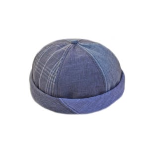 Puede incluir: Gorra vaquera azul con borde enrollado. La gorra presenta un estampado de cuadros en la corona y un borde azul liso. El sombrero es de estilo clásico, adecuado para ropa informal. Fabricado con un tejido suave y duradero.
