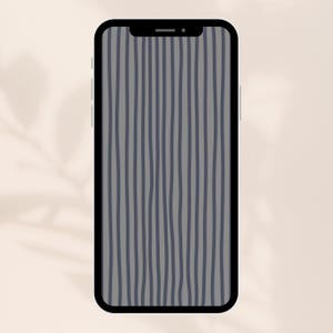 Op de afbeelding: Een smartphone met een zwarte rand toont een grijze achtergrond met verticale, golvende, donkerblauwe strepen. De telefoon staat tegen een zachte, neutrale achtergrond met subtiele schaduwdetails.