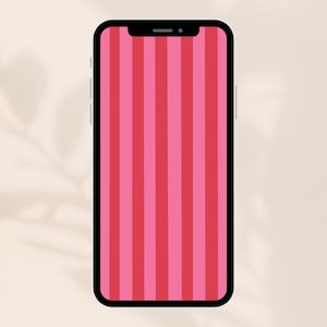 May include: A black smartphone displays a pink and red striped pattern on its screen. The phone is set against a neutral background, with soft shadows suggesting a natural light source.