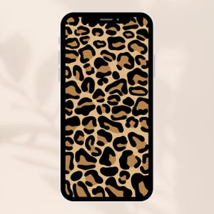 May include: A black smartphone case with a leopard print design. The case features a pattern of brown and black spots, resembling animal print. The phone is displayed against a neutral background.