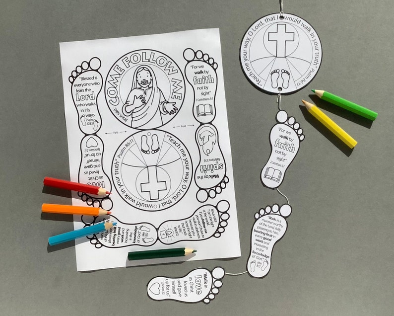 May include: A black and white printable craft featuring Bible verses and illustrations. The design includes a central circle with a cross and footprints, along with foot-shaped cutouts and colored pencils. The text includes "Come Follow Me" and Bible verses.