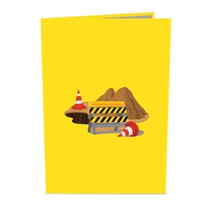 Op de afbeelding: Een geel bouwteken met zwarte strepen, twee oranje verkeerskegels en een hoop aarde. Het bord staat "Weg afgesloten".