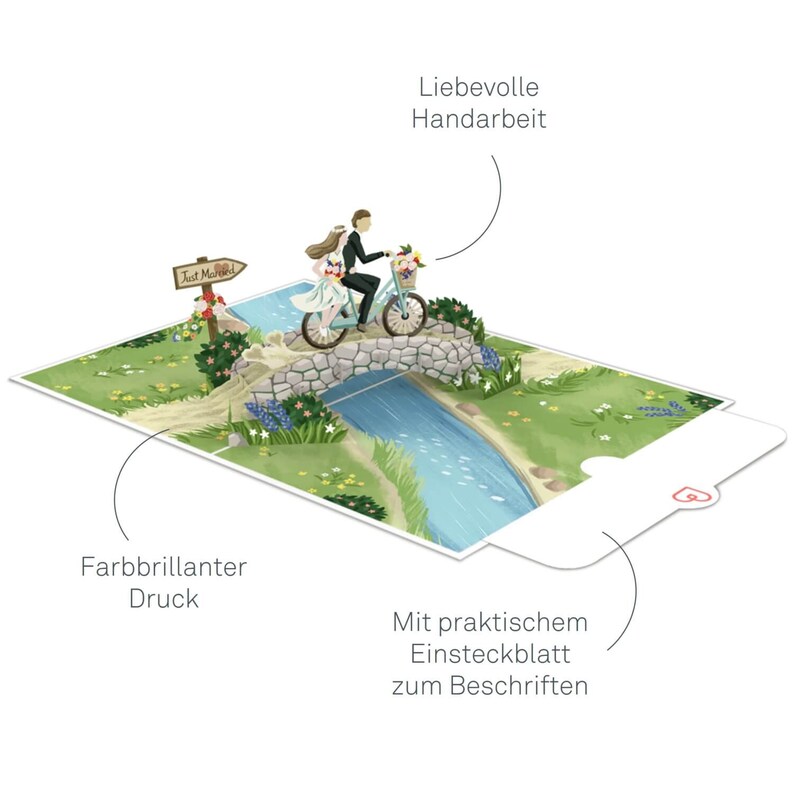 May include: A 3D pop-up card featuring a bride and groom riding a bicycle over a stone bridge. The card has a 'Just Married' sign and a blue river. The card is handmade and has a blank insert for writing a message.