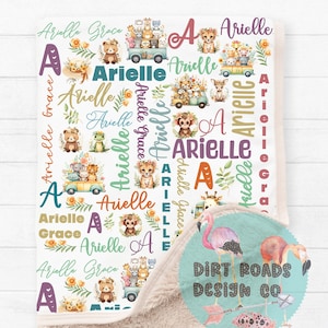 Könnte beinhalten: Eine weiße und beige Decke mit einem farbenfrohen Design, das verschiedene Tiere zeigt, darunter Bären, Affen, Tiger und Giraffen. Die Decke ist mit dem Namen "Arielle" verziert, der mehrmals in verschiedenen Farben und Schriftarten wiederholt wird. Die Decke zeigt auch einen rosa Flamingo und den Text "DIRT ROADS DESIGN CO".