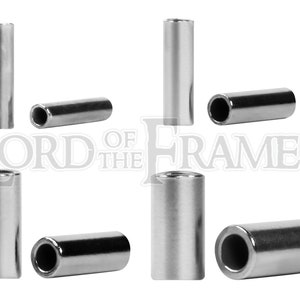 May include: Eight silver metal tubes, each with a hollow centre, are arranged in a grid pattern on a white background. The tubes are approximately 2.5 cm in diameter and 5 cm in length.