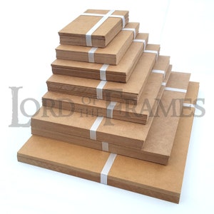 May include: A stack of brown cardboard squares of various sizes, bundled together with white tape. The squares are arranged in a pyramid shape, with the largest square at the bottom and the smallest square at the top.