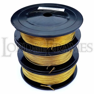 May include: Three spools of gold-coloured wire wound around black plastic spools. The wire is used for picture framing.