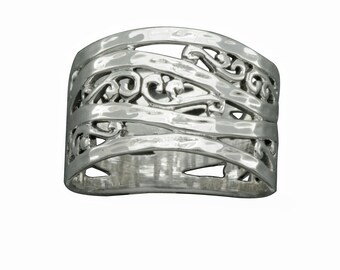Puede incluir: Anillo de plata con una banda ancha que presenta un diseño delicado e intrincado de líneas y espirales entrelazadas.