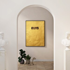 May include: A framed artwork featuring a gold leaf background with a rectangular cutout revealing the eyes of the Mona Lisa. The artwork is displayed in a white arched doorway, flanked by classical busts and potted plants.