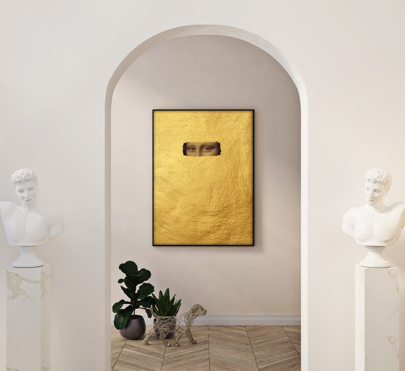 May include: A framed artwork featuring a gold leaf background with a rectangular cutout revealing the eyes of the Mona Lisa. The artwork is displayed in a white arched doorway, flanked by classical busts and potted plants.