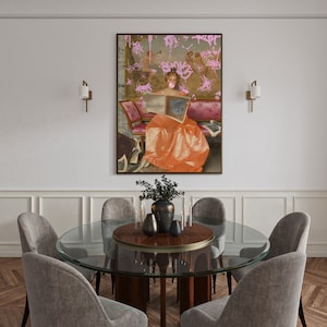 May include: A round glass dining table with a wood top and six gray upholstered chairs. A painting of a woman in a long orange dress with pink graffiti on the wall behind the table.
