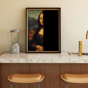 May include: A framed print of the Mona Lisa, with half of the image obscured by black. A grey blender sits to the left, and a gold tap is on the right. The artwork is displayed on a marble countertop.
