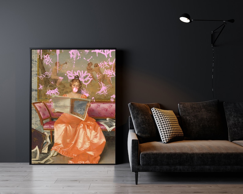 May include: A framed painting of a woman in a long orange dress sitting on a pink couch and reading a book. The painting is covered in pink graffiti.