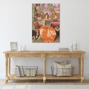 May include: A painting of a woman in a long orange dress sitting on a couch and reading a book. The background is a pink and white wall with pink graffiti.