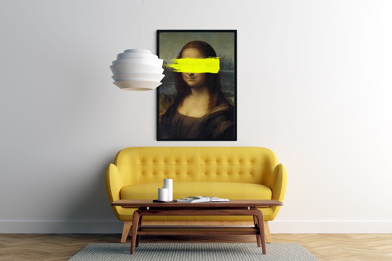 May include: A yellow sofa with a coffee table in front of it. A black framed print of the Mona Lisa with a yellow stripe painted over her eyes hangs on the wall above the sofa.