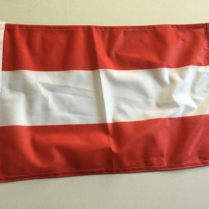 May include: A red, white, and red Austrian flag with grommets on the left side.