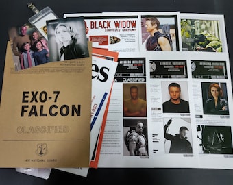 Könnte beinhalten: Eine Sammlung von Drucksachen, darunter ein brauner Ordner mit der Aufschrift "EXO-7 FALCON CLASSIFIED" und verschiedene Charakterbilder. Die Bilder enthalten Text und das Logo der Air National Guard. Weitere Bilder zeigen "BLACK WIDOW" und "AVENGERS INITIATIVE" Materialien.