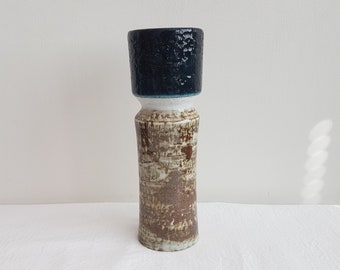 Op de afbeelding: Een keramische vaas met een getextureerd bruin en wit lichaam en een donkerblauwe bovenkant.