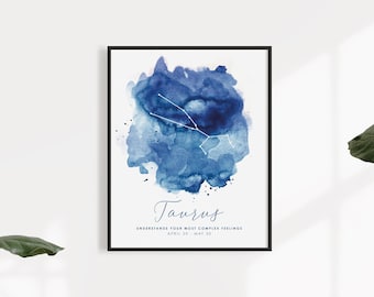 Könnte beinhalten: Ein gerahmter Kunstdruck mit einem blauen Aquarellfleck und der weißen Konstellation Stier darüber. Unter der Grafik steht der Text Taurus, Understands your most complex feelings sowie das Datum vom 20. April bis 20. Mai.
