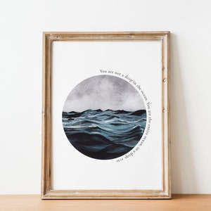 May include: A framed print with a watercolor illustration of a stormy ocean in a circle. The text "You are not a drop in the ocean. You are the entire ocean, in a drop" is written around the circle.