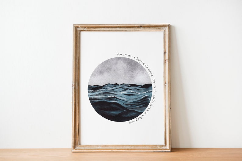 May include: A framed print with a watercolor illustration of a stormy ocean in a circle. The text "You are not a drop in the ocean. You are the entire ocean, in a drop" is written around the circle.