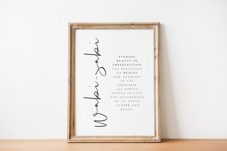 May include: A framed print with the text "Wabi-sabi" written vertically on the left side of the frame. The text on the right side of the frame reads "Finding beauty in imperfection, the discovery of beauty and harmony in the unfinished and simple things in life, the acceptance of the cycle of life and death."