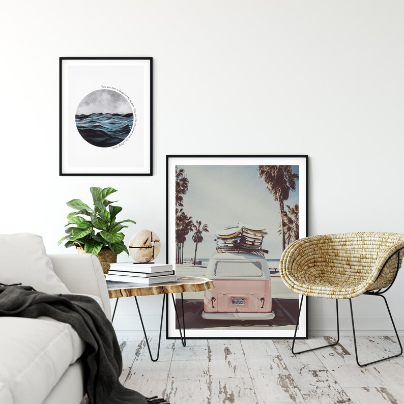 May include: A framed print of a watercolor painting of ocean waves with the text "You are not a drop in the ocean, you are the entire ocean in a drop." A framed photograph of a pink vintage van with surfboards on the roof parked on a beach with palm trees.