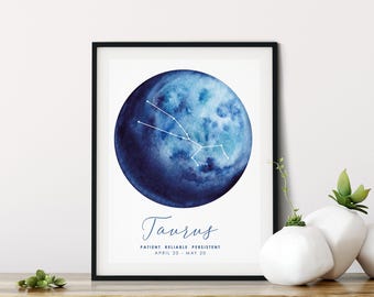 Könnte beinhalten: Ein gerahmter Kunstdruck mit einem aquarellierten blauen Mond und dem weißen Sternbild Stier. Unter dem Mond steht der Text Taurus, Patient Reliable Persistent sowie April 20 - May 20 in einer dunkelblauen Schreibschrift und serifenloser Schrift.
