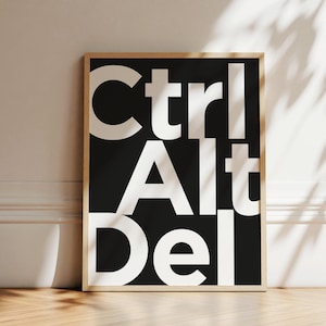 Peut inclure: Une affiche murale rectangulaire dans un cadre en bois clair présentant un fond noir avec le texte blanc Ctrl, Alt et Del empilé verticalement dans une police sans empattement en gras. Le design est centré dans le cadre, créant un affichage graphique contrasté.