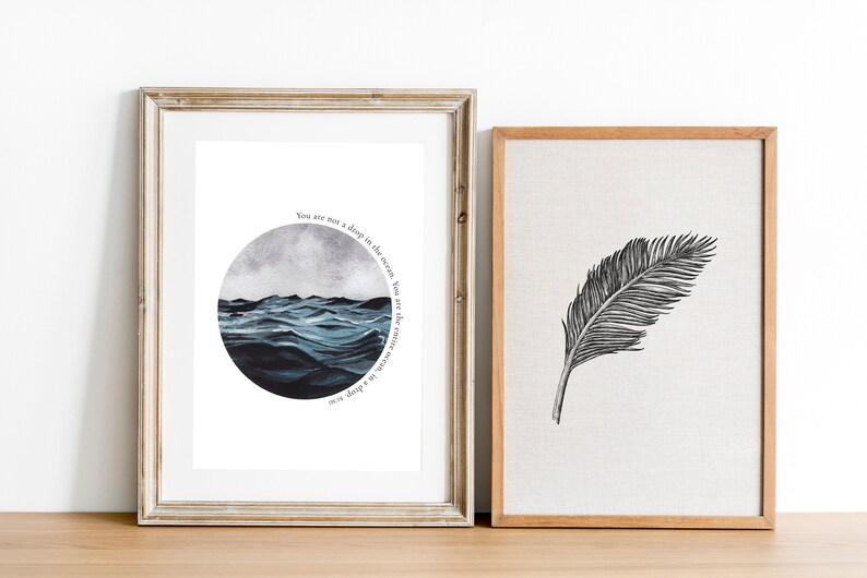 May include: Two framed prints, one with a watercolor painting of a stormy sea in a circle with the text "You are not a ship in the ocean, but the ocean itself", and the other with a black and white illustration of a feather.