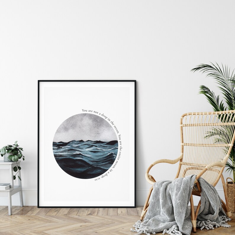 May include: A framed print with a watercolor illustration of a blue ocean with waves. The text "You are not a drop in the ocean. You are the entire ocean in a drop" is written in a circle around the image.