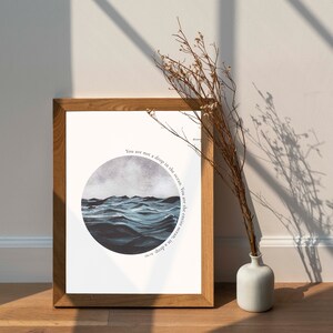 May include: A framed print with a watercolor illustration of a blue ocean with waves. The text on the print reads "You are not a drop in the ocean, You are the entire ocean, in a drop."