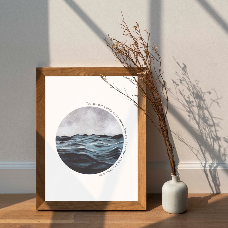 May include: A framed print with a watercolor illustration of a blue ocean with waves. The text on the print reads "You are not a drop in the ocean, You are the entire ocean, in a drop."